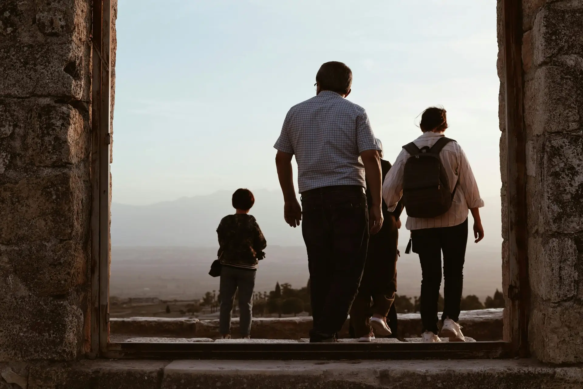 A family explores the ancient ruins of Pamukkale, capturing the beauty of Turkish landscapes at sunset.