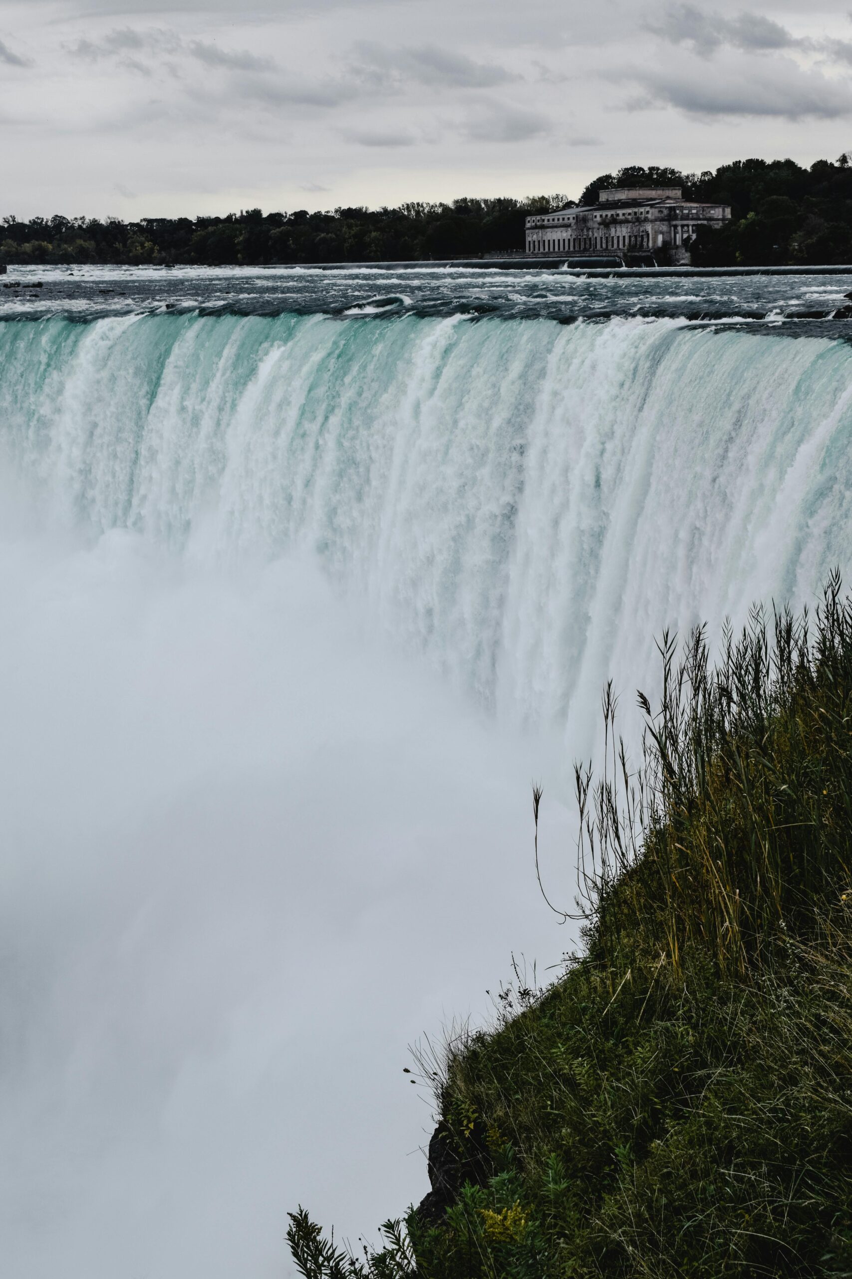 Breathtaking view of water cascading over Niagara Falls surrounded by nature, Ontario, Canada.